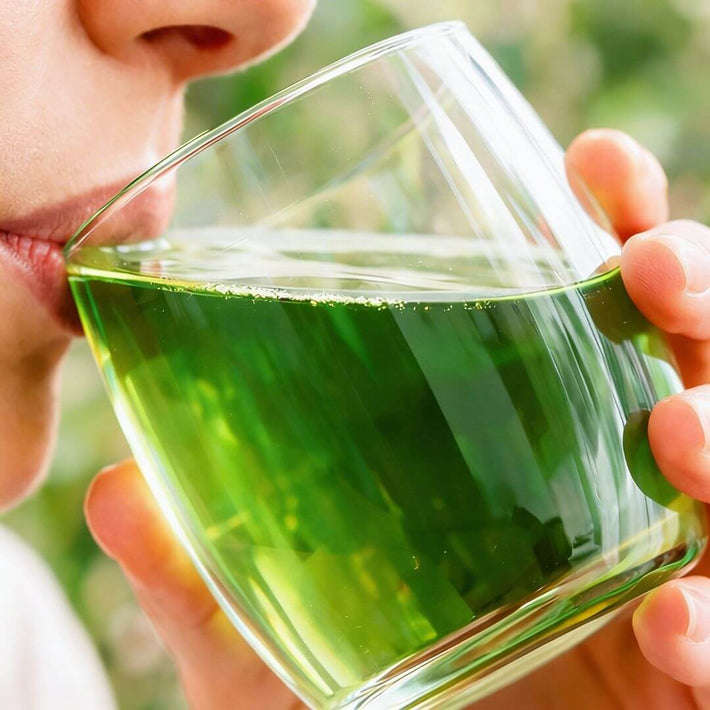 Persona che beve un bicchiere d'acqua